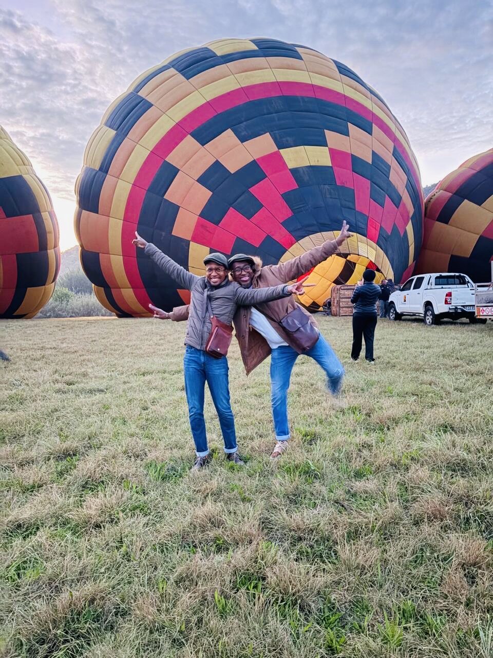 A couple celebrating in the field in front of the balloons