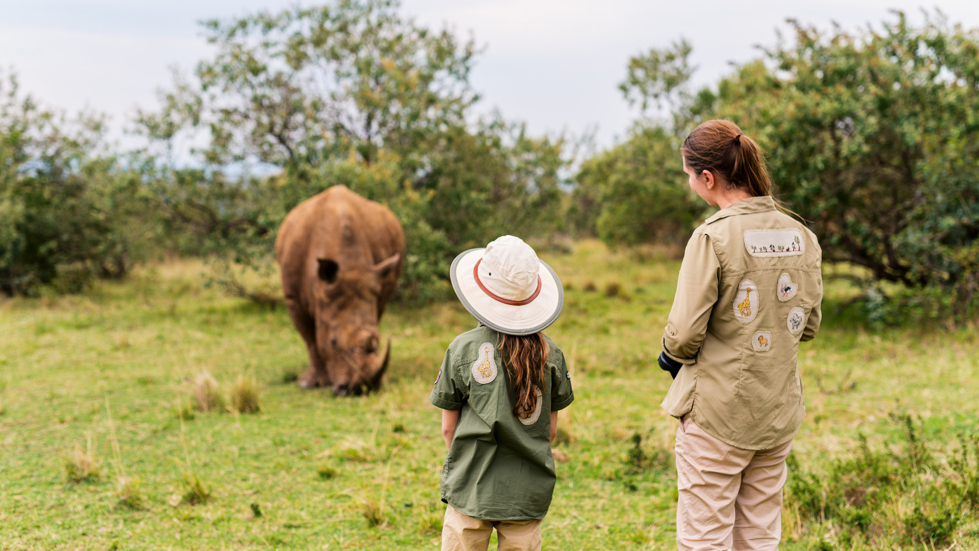 Children watching African wildlife with wonder and excitement on a family safari