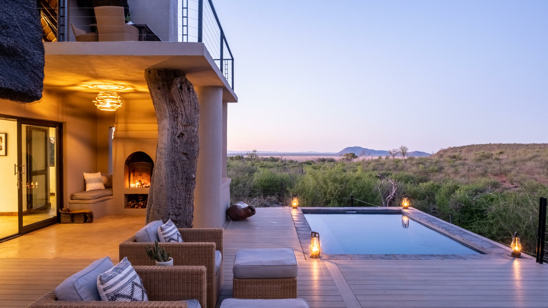 A luxury safari suite with a private plunge pool on a deck overlooking the bush at dusk