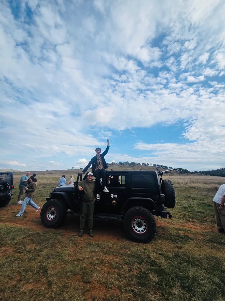 Two friends posing together beside a safari jeep at the Lion and Safari Park