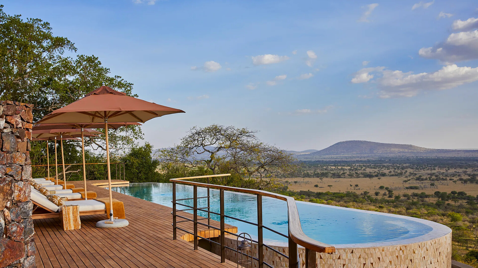 A luxury fly-in safari lodge deck with an infinity pool overlooking the endless African savanna — this is what waits at the end of the airstrip
